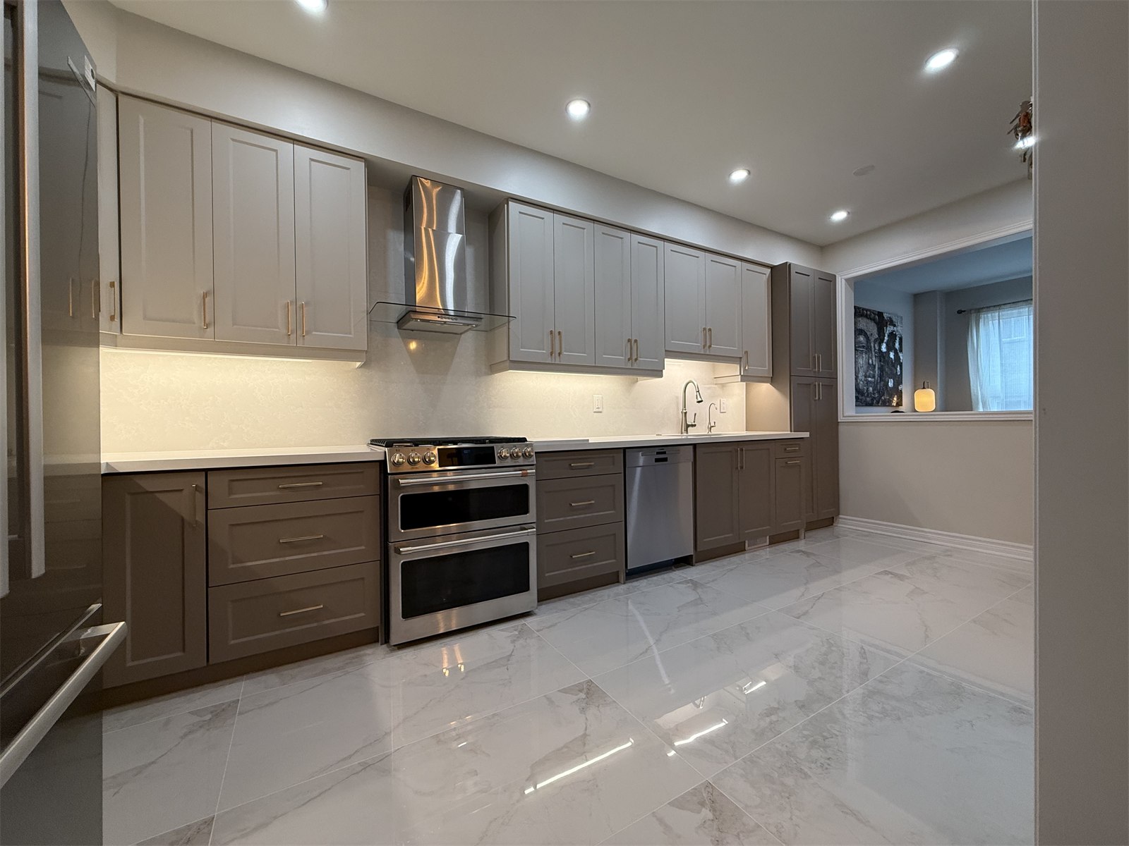 Oakville kitchen front elevation with range hood, tall cabinetry, and polished floor