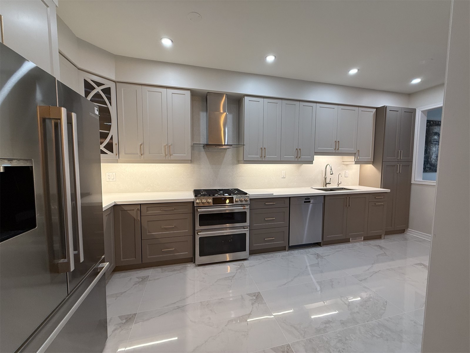 Oakville kitchen view with refrigerator, full-height cabinetry, and open floor area