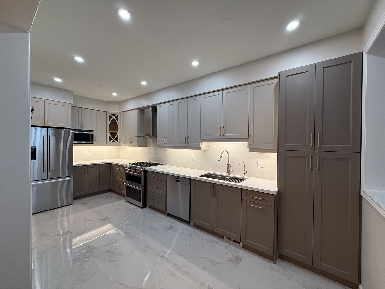Wide-angle view of Oakville kitchen cabinetry, appliances, and bright finishes