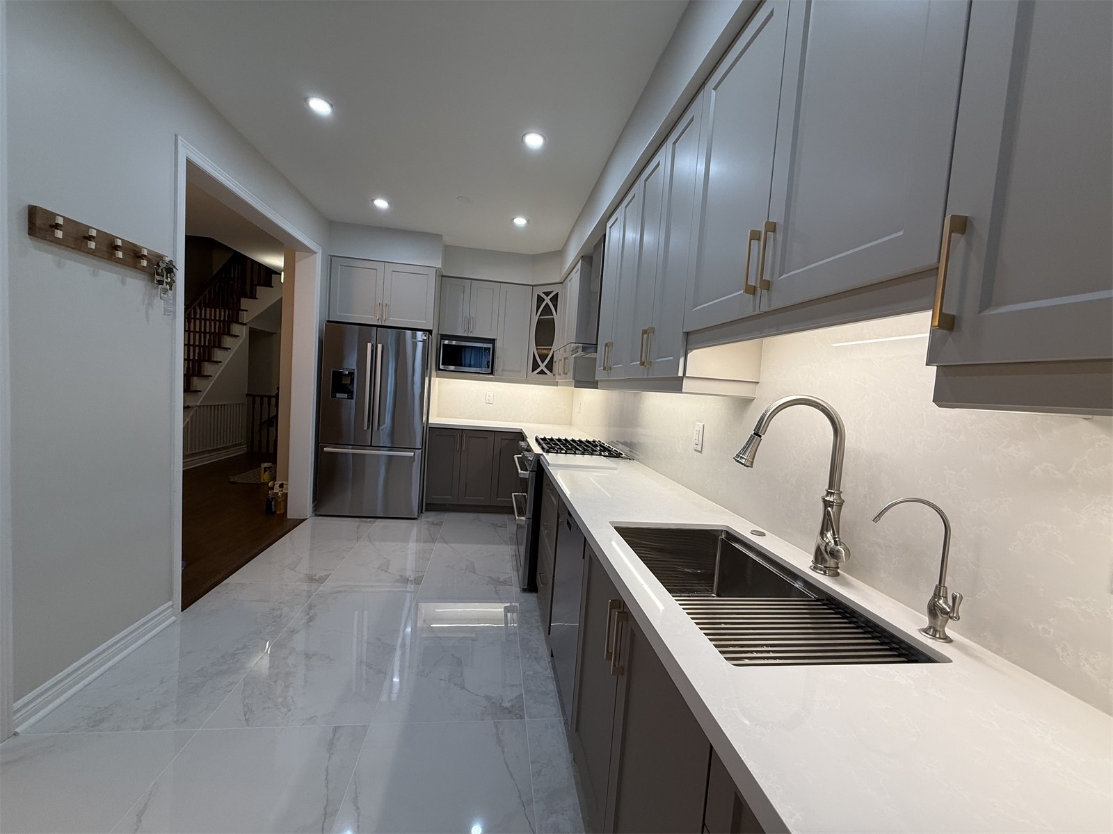 Oakville kitchen sink wall with long counter run and under-cabinet lighting